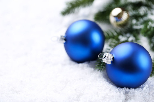 Christmas baubles with fir tree branches on white snow - Fotoğraf, Görsel