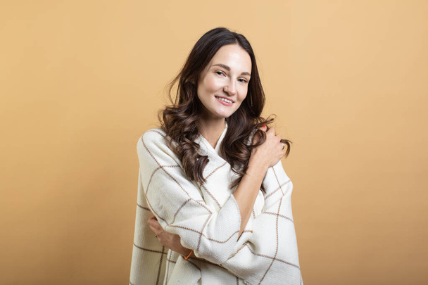 La imagen de una joven hermosa mujer en un suéter blanco y a cuadros posando sobre un fondo naranja aislado muestra diferentes emociones
 - Foto, Imagen