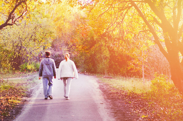 Два человека гуляют в осеннем парке
. - Фото, изображение