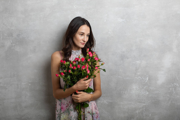 Primer plano retrato de mujer joven atractiva en vestido de verano celebración ramo de rosas, chica feliz
 - Foto, Imagen
