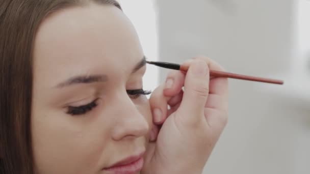 Επαγγελματική makeup artist γυναίκα αναδεύει κρέμα μακιγιάζ σε μια παλέτα. - Πλάνα, βίντεο