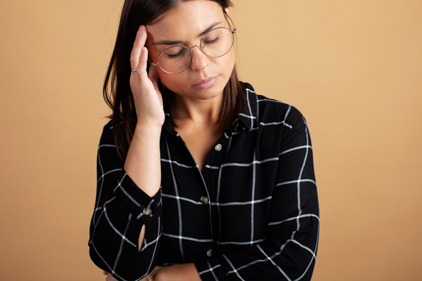 Portrét mladé ženy v brýlích. Mladá žena trpí bolestí hlavy - Fotografie, Obrázek