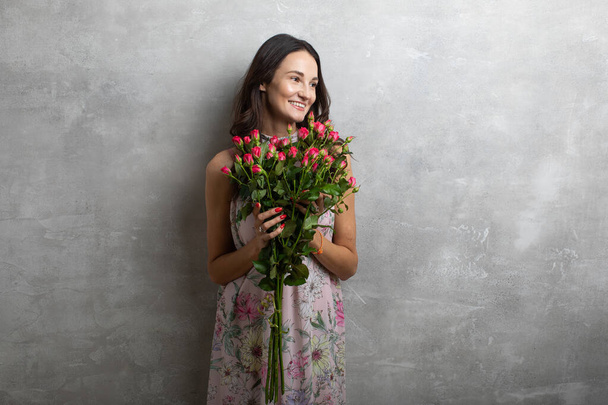 Primer plano retrato de mujer joven atractiva en vestido de verano celebración ramo de rosas, chica feliz
 - Foto, imagen