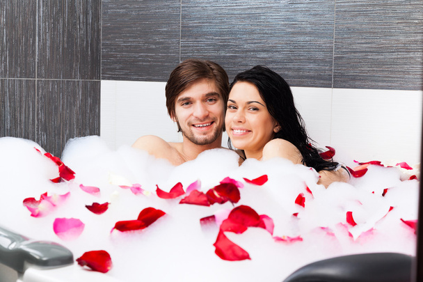 Young happy couple lying in jacuzzi - Fotoğraf, Görsel