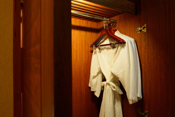Close up of clothes hanger and twins bathrobe - Photo, Image