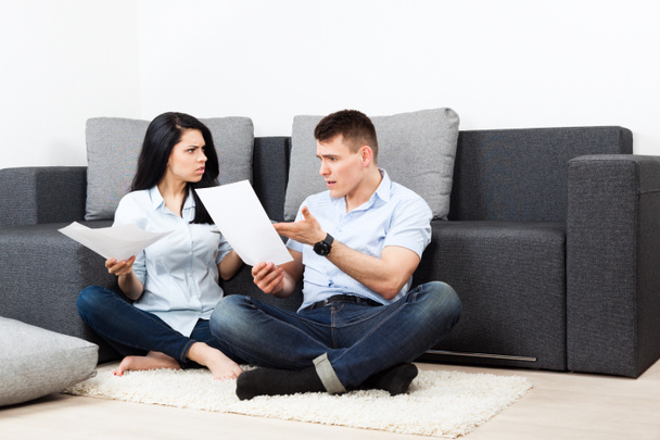 Unhappy couple reading a letter in the living room- money problem concept - Φωτογραφία, εικόνα