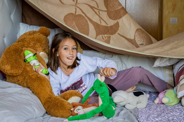 Little girl playing in bed - Fotó, kép