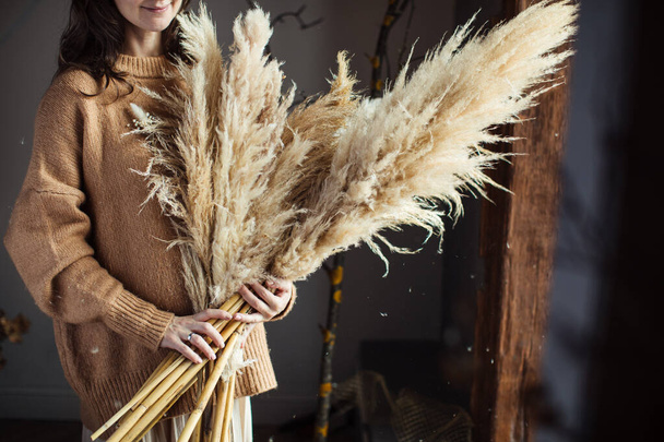 Beautiful autumn bouquet of dry materials in the hands of a woman. Cortaderia - Foto, Imagem
