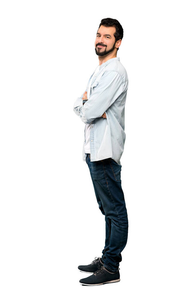 Full-length shot of Handsome man with beard with arms crossed and looking forward over isolated white background - Fotó, kép