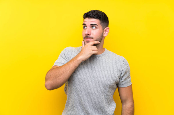 Young handsome man over isolated yellow background thinking an idea - Fotoğraf, Görsel