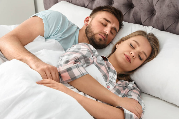 Молода пара спить разом у ліжку вдома
 - Фото, зображення