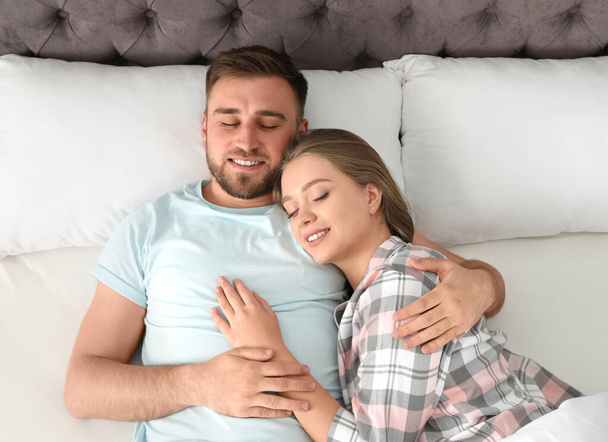 Young couple sleeping together in bed at home, top view - Photo, Image