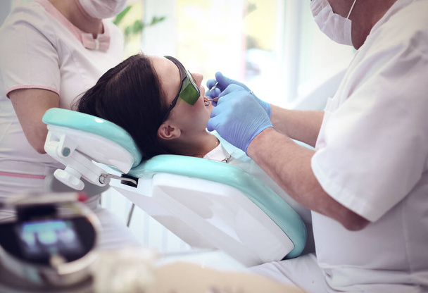 Man dentist working at his patients teeth - Zdjęcie, obraz