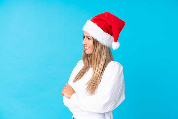 Girl with christmas hat over isolated background looking to the side - 写真・画像