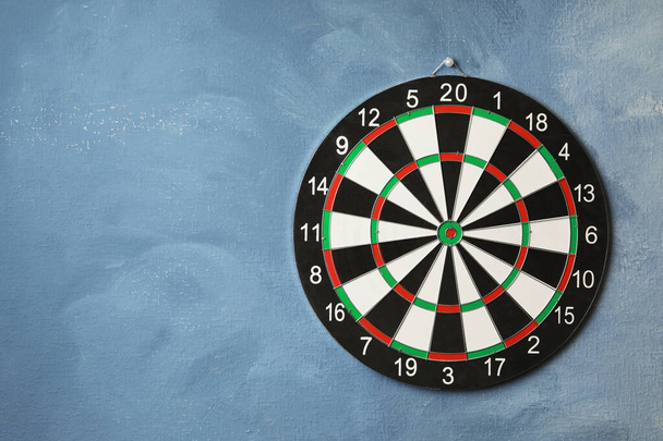 Dart board hanging on blue textured wall. Space for text - Fotografie, Obrázek