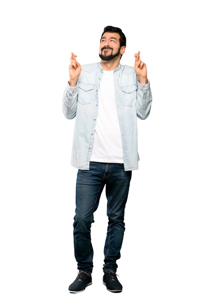 Полнометражный снимок Красавчика с бородой и скрещенными пальцами, желающего лучшего на изолированном белом фоне
 - Фото, изображение