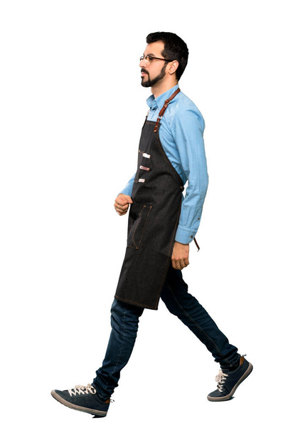 Full-length shot of Man with apron walking over isolated white background - Фото, зображення