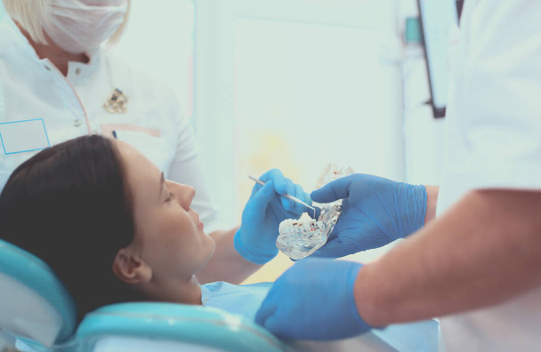 Portrait of a smiling dentist standing in dental clinic - Foto, Imagem