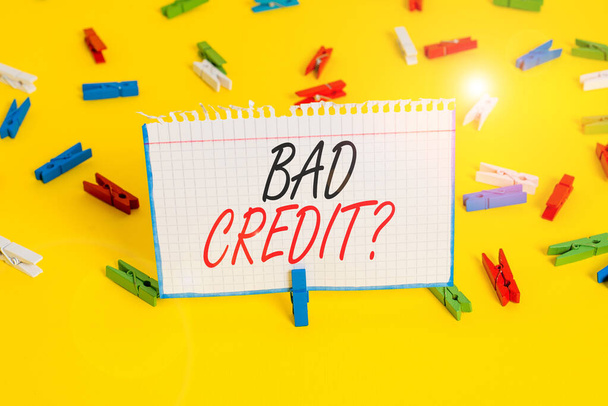 Egy levelet, amin Bad Creditquestion áll. Üzleti fotó bemutató képtelensége demonstráló visszafizetni az adósságot időben és teljes színes ruhacsap papírok üres emlékeztető sárga padló háttér offi - Fotó, kép