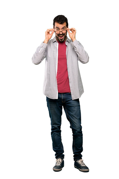 Full-length shot of Handsome man with beard with glasses and surprised over isolated white background - Foto, Imagem