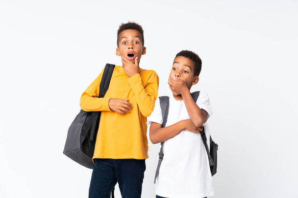 Two boys African American students over isolated white background and doing surprise gesture - Foto, Imagem