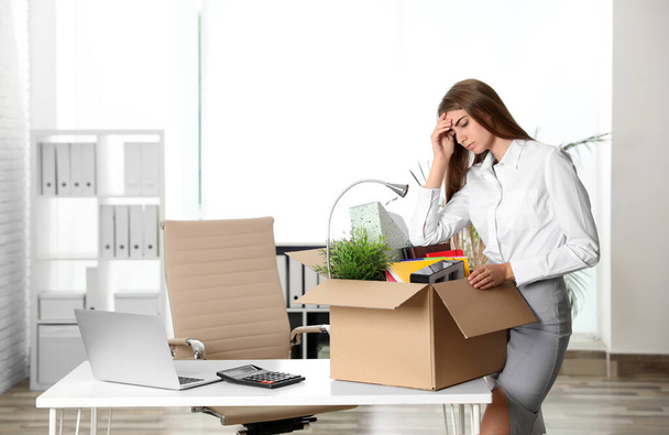 Upset young woman packing stuff in box at office - Фото, зображення