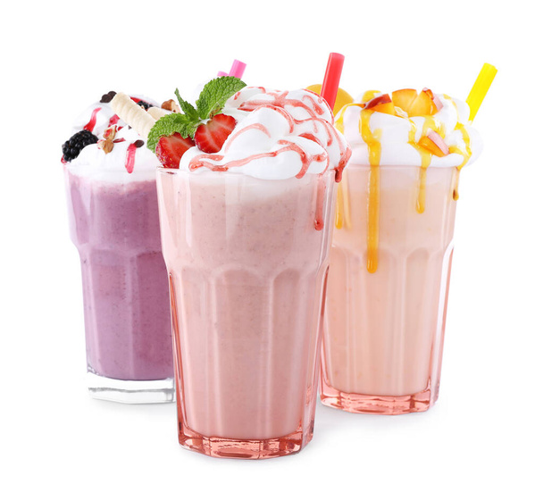 Different tasty milk shakes in glasses on white background - Foto, Imagem