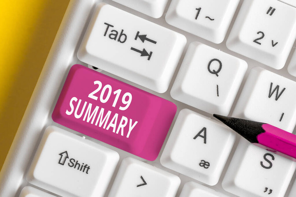 Writing note showing 2019 Summary. Business photo showcasing brief comprehensive especially covering the main points of 2019 White pc keyboard with note paper above the white background. - Photo, Image