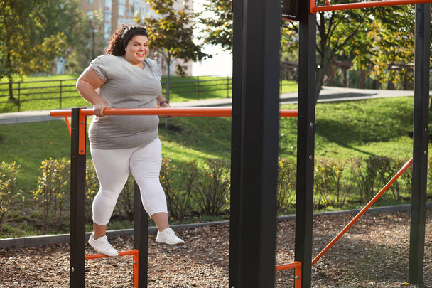 Beautiful overweight woman training on sports ground - Фото, зображення