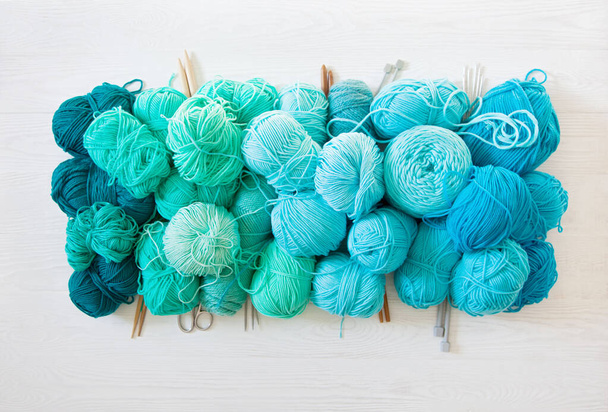 Yarn of green, turquoise, aquamarine and blue colors. White wood - Foto, imagen