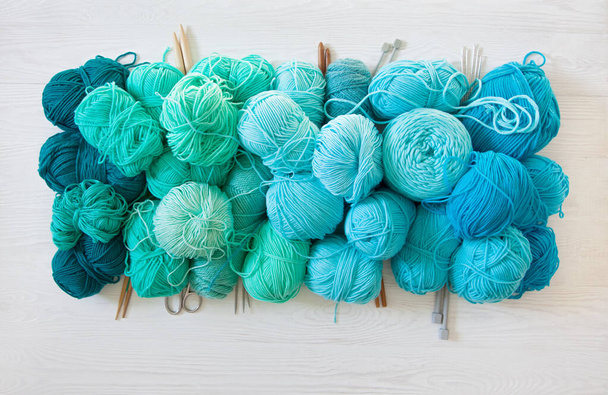 Yarn of green, turquoise, aquamarine and blue colors. White wood - Foto, Imagen