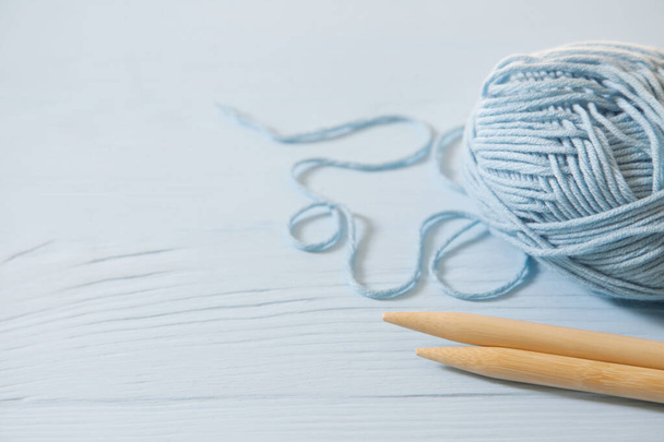 Yarn of grey  colors. Background blue old wooden. Knitting needl - Foto, afbeelding