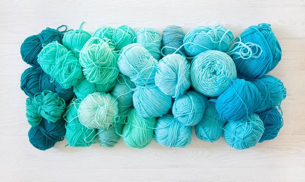 Yarn of green, turquoise, aquamarine and blue colors. White wood - Foto, Bild