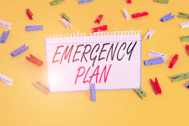 Writing note showing Emergency Plan. Business photo showcasing procedures for handling sudden or unexpected situations Colored clothespin papers empty reminder yellow floor background office. - Photo, Image