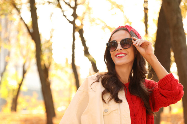 Beautiful woman wearing sunglasses in park. Autumn walk - Φωτογραφία, εικόνα