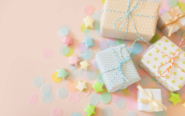 Gift boxes and pastel color confetti. Pink background. - Фото, зображення