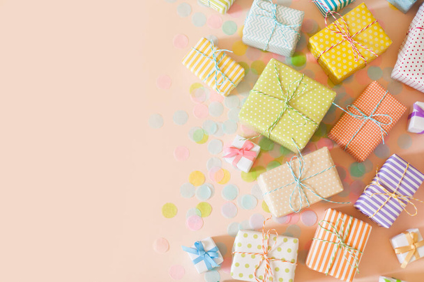 A lot of gifts and pastel color confetti. Pink background. - 写真・画像