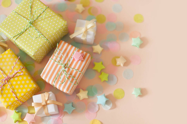 Gift boxes and pastel color confetti. Pink background. - Foto, imagen