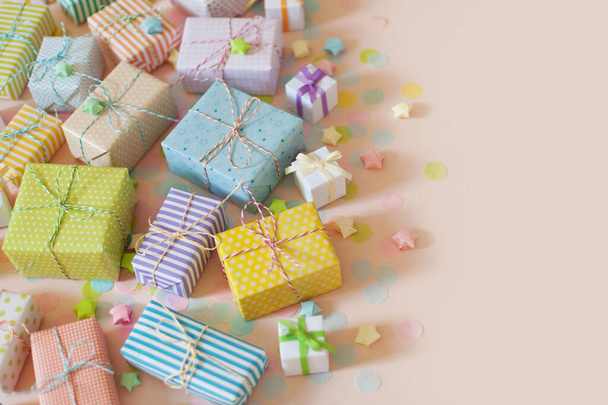 A lot of gifts and pastel color confetti. Pink background. - Foto, Imagem
