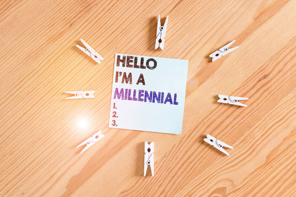 Word writing text Hello I M A Millennial. Business concept for demonstrating reaching young adulthood in current century Colored clothespin papers empty reminder wooden floor background office. - Photo, Image