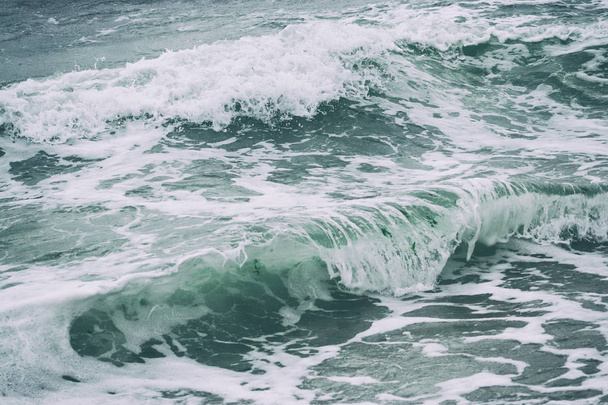海岸のスプレーや泡で波が閉じるのは抽象的な背景です。クローズアップ、浅い焦点. - 写真・画像