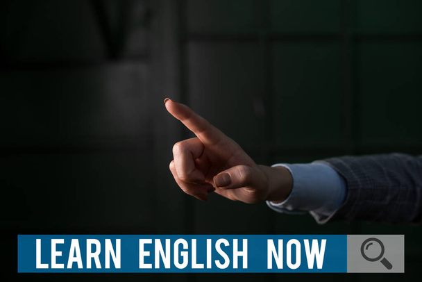 Conceptual hand writing showing Learn English Now. Business photo text gain or acquire knowledge and skill of english language Finger pointing in the Dark with hand pointing in the copy space. - Photo, Image