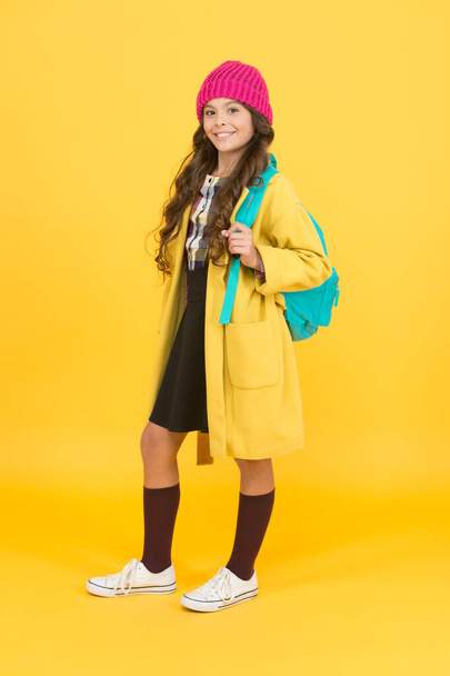 Adding touch of charm for standard school uniform. Happy school child yellow background. Little girl back to school. School fashion for autumn. Primary education - Foto, imagen
