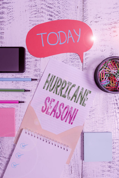 Text sign showing Hurricane Season. Conceptual photo time when most tropical cyclones are expected to develop Envelop speech bubble smartphone sheet pens spiral notepads clips wooden. - Photo, Image