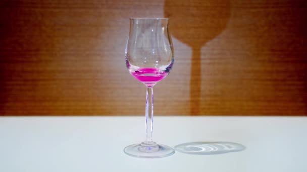 Glazen beker vult zich met roze vloeistof - Video