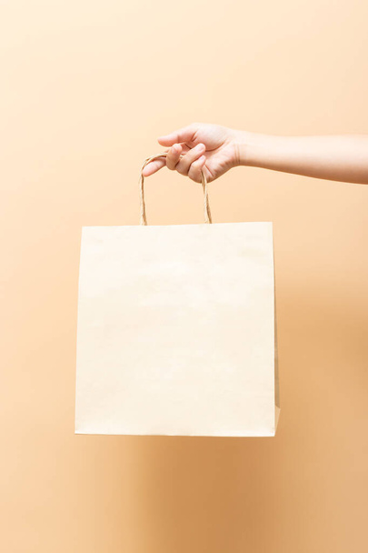 Hand holding a paper bag isolated on background - Fotografie, Obrázek