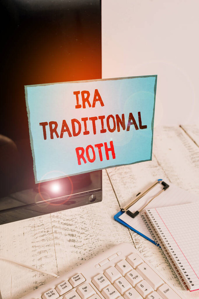 Writing note showing Ira Traditional Roth. Business photo showcasing are tax deductible on both state and federal Note paper taped to black computer screen near keyboard and stationary. - Photo, Image