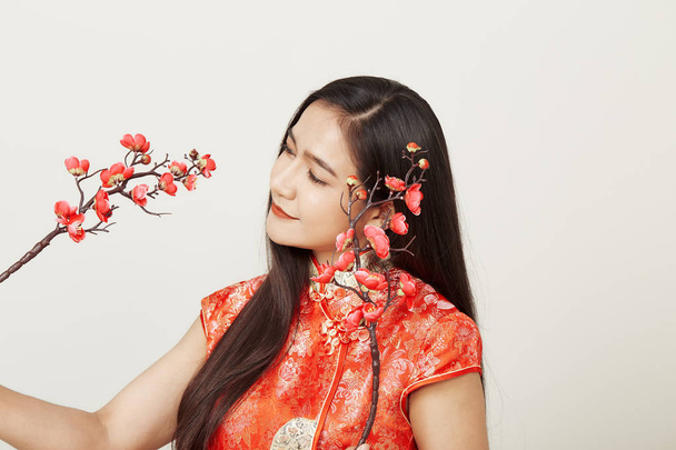 Woman in traditional chinese red dress with plum flowers - Foto, afbeelding