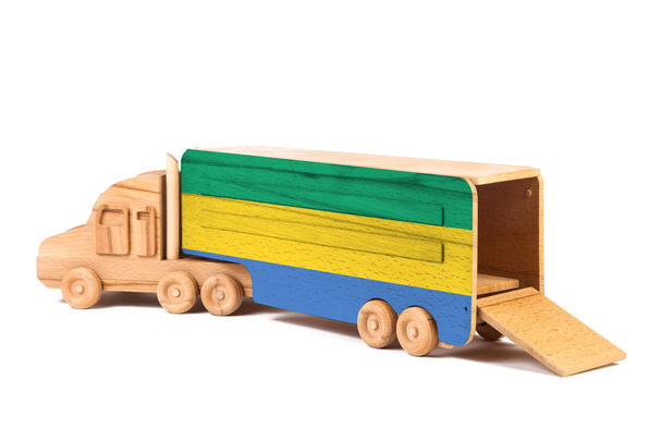 Зблизька дерев'яна іграшкова вантажівка з розписаним національним прапором Габоном. Концепція експорту-імпорту, транспорту, національного постачання товарів.  - Фото, зображення