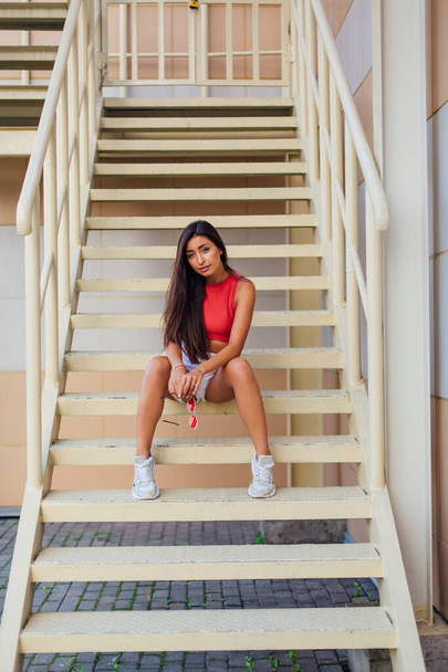 Street fashion summer portrait of a women on stairs outdoors. - Foto, Imagem